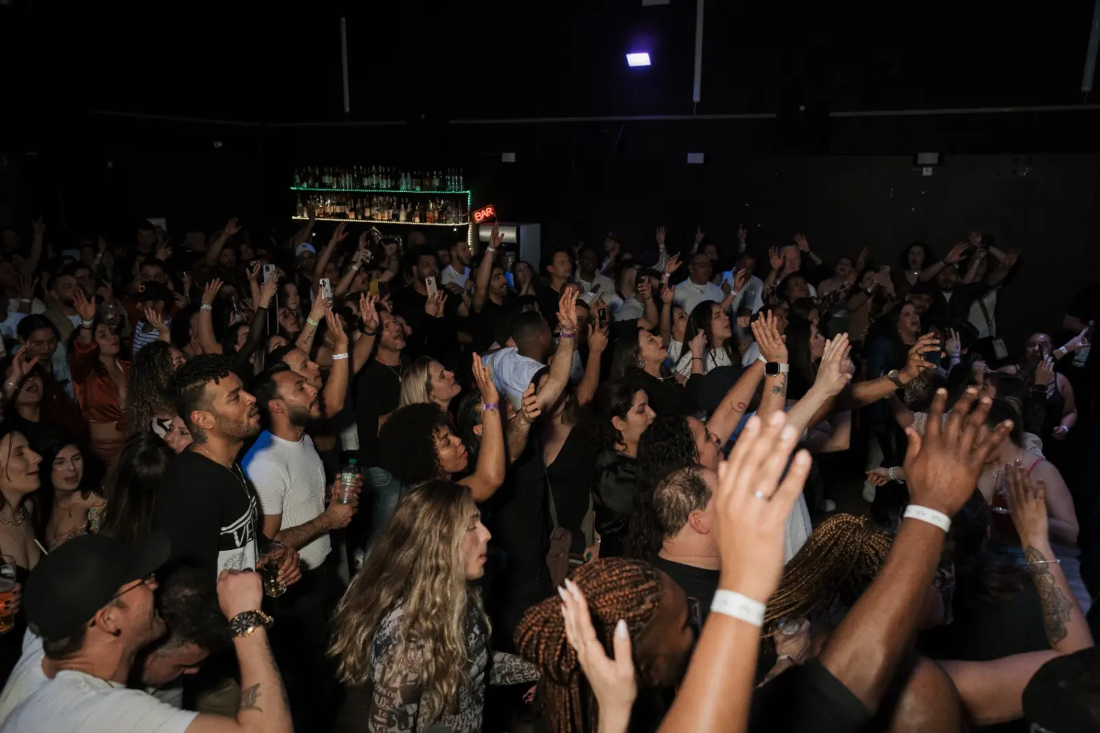 Packed crowd with hands up at Kino Events House